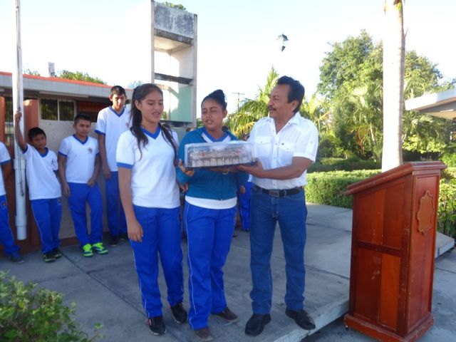 Director entregando un estímulo al grupo que obtuvo mejor aprovechamiento escolar